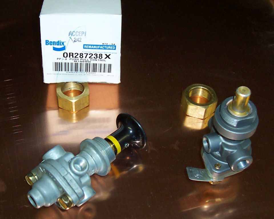 Two Bendix PP-8 push-pull air brake valves and brass nuts beside their remanufactured box