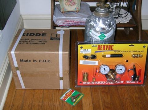 1988 Ford Bronco - A fire extinguisher box and a regulator kit are displayed on a wooden floor.