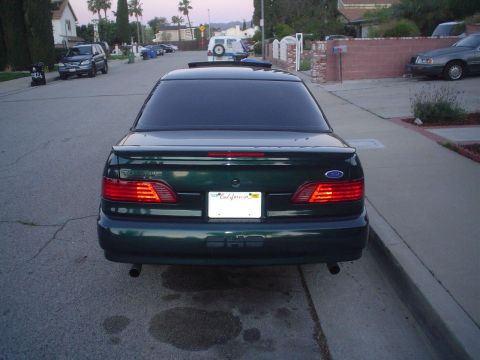 1993 Ford Taurus - Rear view of a dark green 1993 Ford Taurus sedan parked on a residential street.