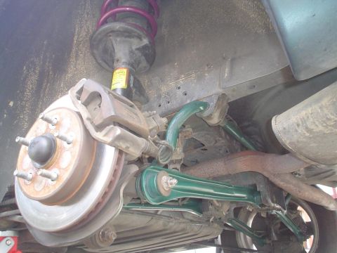 1993 Ford Taurus - The underside of a vehicle shows the rear suspension system, including the brake rotor and caliper.