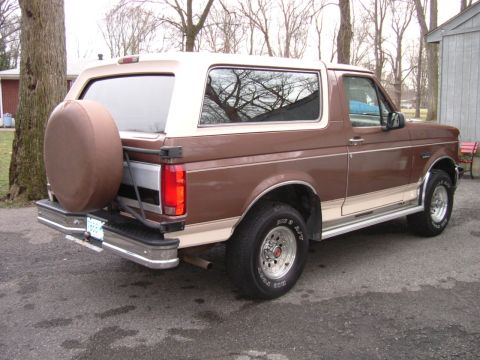 1993 Ford Bronco - This two-tone Ford Bronco is shown from the rear passenger side, with a spare tire mounted on the tailgate.