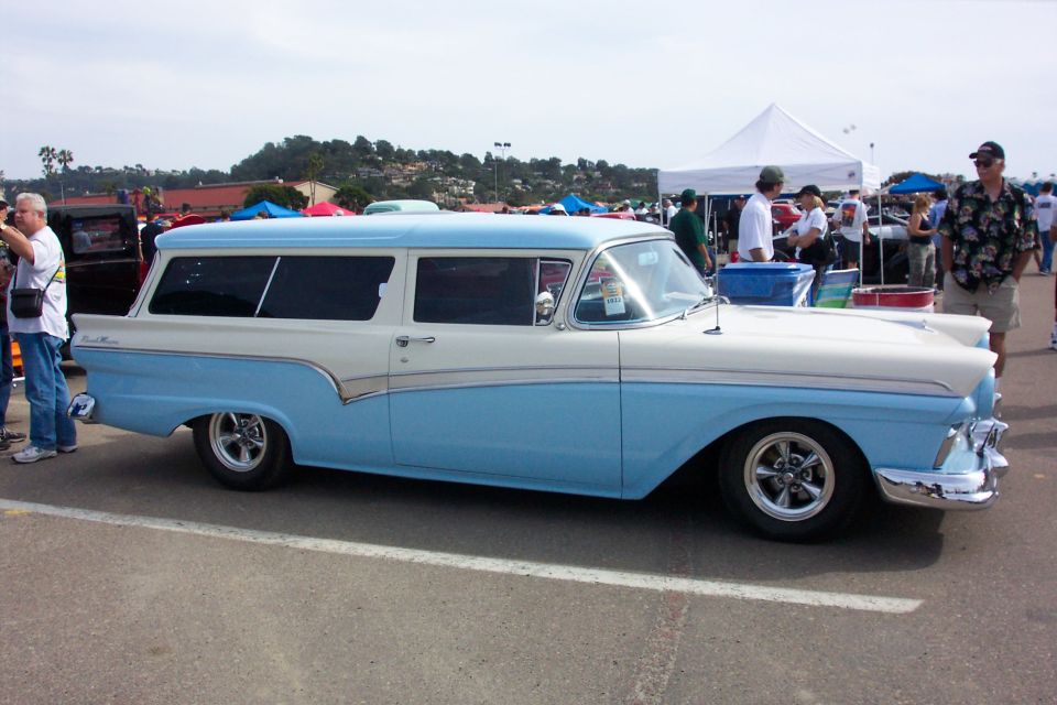 Two-tone blue and white 1957 Ford two-door wagon with chrome wheels at outdoor show