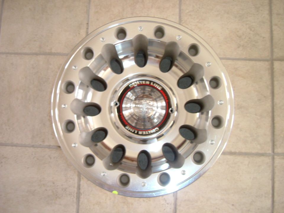 Polished Centerline aluminum wheel lying flat on tile floor, showing machined face and Center Line center cap