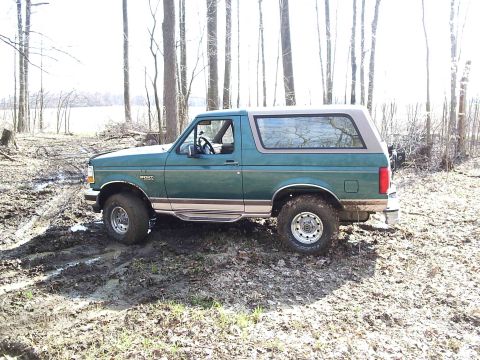 1996 Ford Bronco - This 1996 Ford Bronco is seen from the side, stuck in a muddy, wooded area.