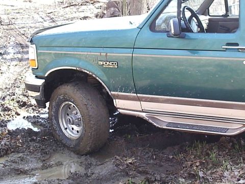 1996 Ford Bronco - This 1996 Ford Bronco is stuck deep in the mud, with its front tire partially submerged.