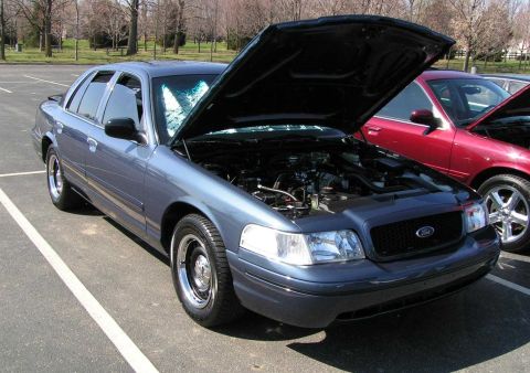 1998 Ford Crown Victoria - Blue 1998 Ford Crown Victoria at a car meet, hood open to display the engine bay.