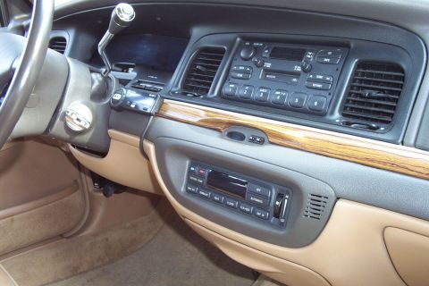 1996 Ford Crown Victoria - Interior view of a car's dashboard, tan upholstery and wood grain accents.