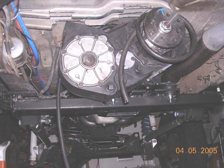 Underbody view of a transfer case and new black crossmember on a truck