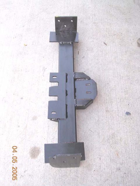 1994 Ford Bronco - Custom fabricated metal bracket assembly with multiple mounting tabs and plates, photographed on concrete.