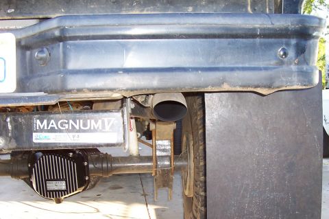 1994 Ford F-150 - Close-up of a vehicle's rear axle and exhaust system, a MAGNUM V label.