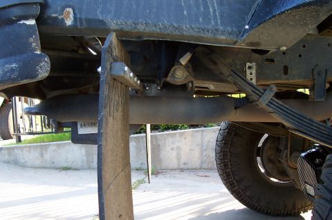 1994 Ford F-150 - Underside view of a vehicle's exhaust system and mud flap, with a Supermotors.net logo.