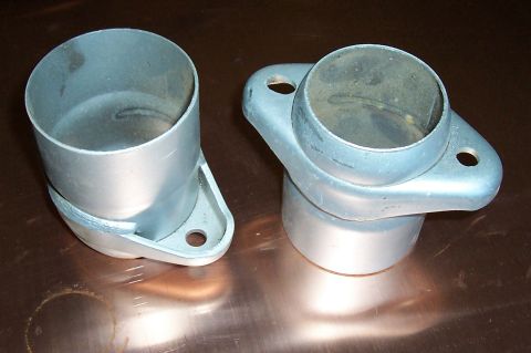 1994 Ford F-150 - Two metal exhaust pipe adapters are shown against a reflective surface.
