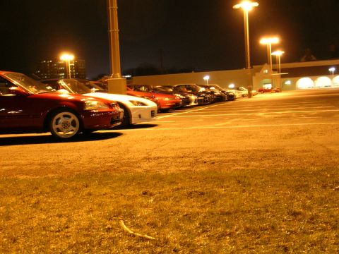 1994 Ford Probe - Several cars are parked in a lot at night, illuminated by streetlights.
