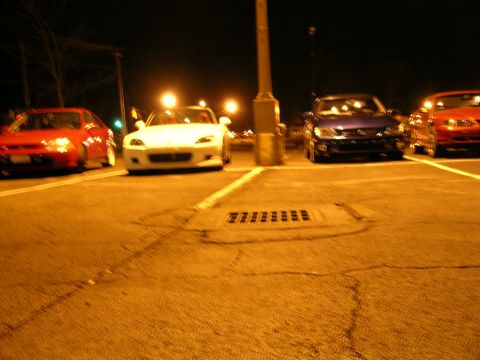 1994 Ford Probe - Several cars are parked in a lot at night, illuminated by streetlights.