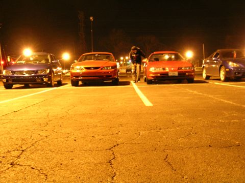 1994 Ford Probe - A red 1994 Ford Probe is parked in a lot at night alongside other vehicles.