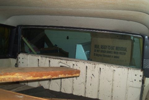 1960 Saleen S7 - The interior of a vehicle is visible, with a box of individual meals seen through the rear window, along with some wooden planks.