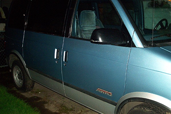 Blue and gray Chevrolet Astro van side view at night
