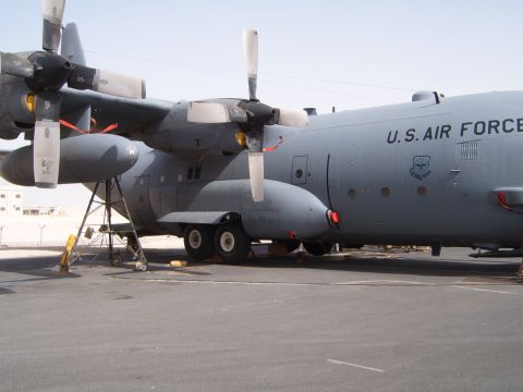 1988 Ford Bronco - A U.S. Air Force C-130 Hercules cargo plane is seen from the side, parked on an airfield.