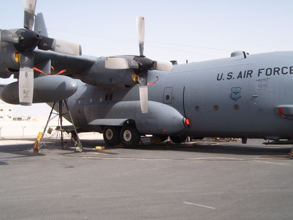 US Air Force C-130 Hercules cargo plane parked on tarmac, showing engines and fuselage
