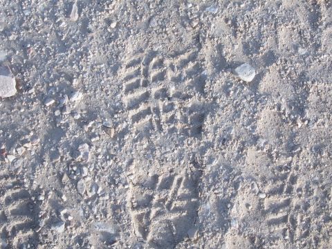 1988 Ford Bronco - A clear shoe print is visible in the sandy ground, showing the tread pattern.