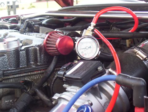 1997 Ford Probe - Close-up of an engine bay showing a pressure gauge and air filter setup.