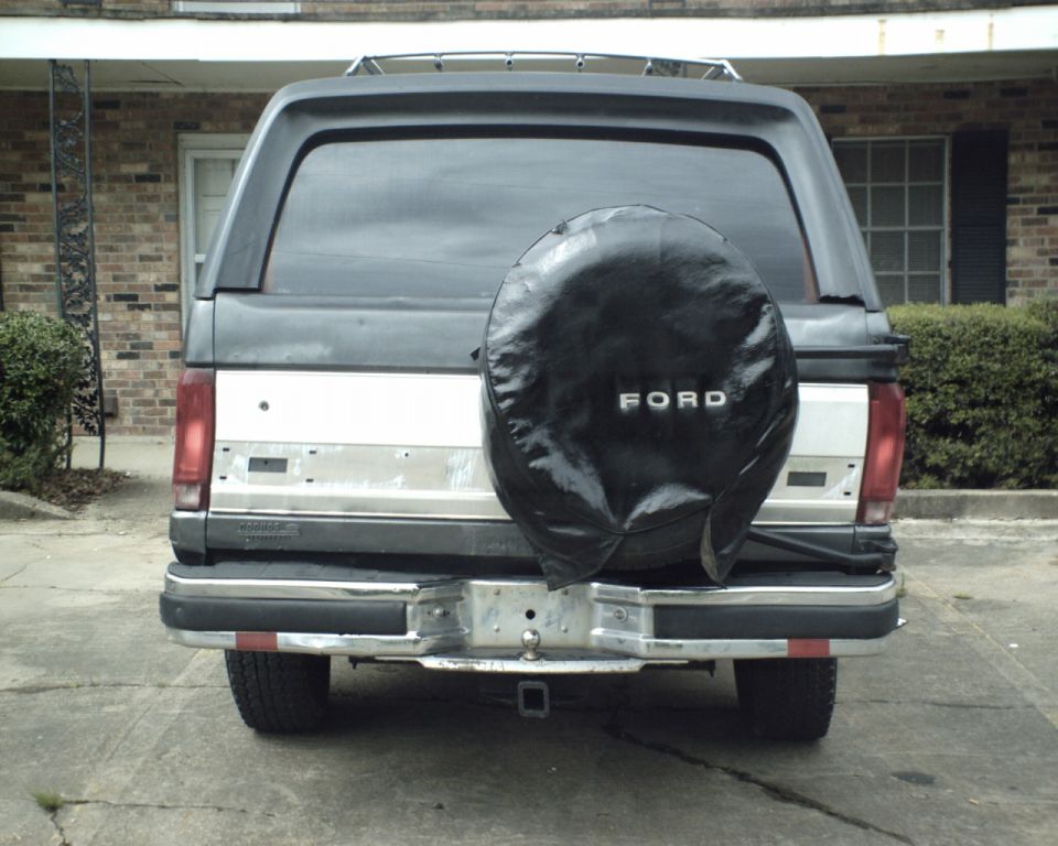 Rear view of a 1987 Ford Bronco with a black spare tire cover showing 'FORD'