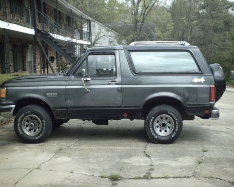 1987 Ford Bronco - This 1987 Ford Bronco is seen from the side, parked in front of a building.