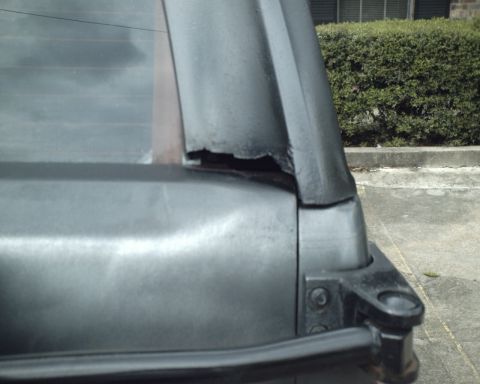 1987 Ford Bronco - Damage to the rear window frame of a vehicle is visible in this close-up shot.