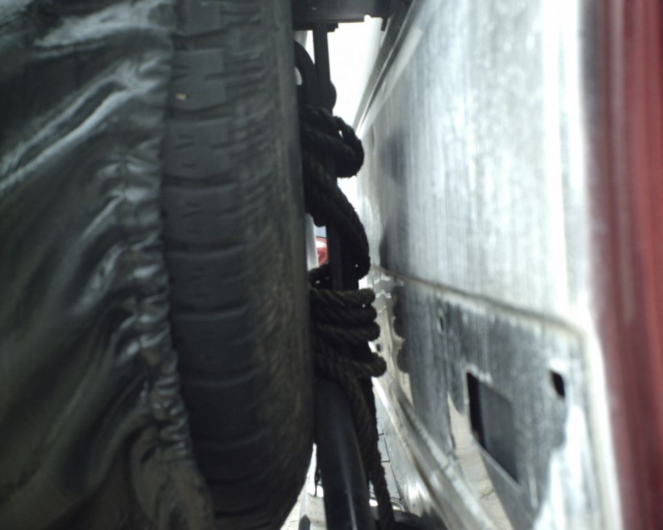 Spare tire and coiled rope secured under a vehicle