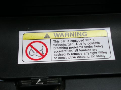 1990 Ford Probe - Sun visor warning label with text and symbols visible.