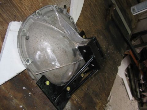1985 Ford LTD Crown Victoria - Differential housing on black brackets with yellow bolts, on a wooden surface.