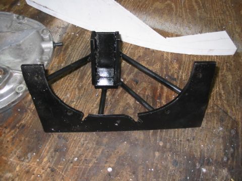 1985 Ford LTD Crown Victoria - A black metal automotive part is shown on a wooden workbench next to a silver differential housing.