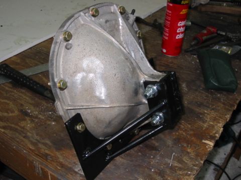 1985 Ford LTD Crown Victoria - A differential housing is shown mounted with a custom bracket on a workbench, with tools and cleaning supplies nearby.
