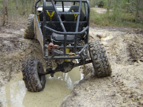 1989 Ford Bronco - This custom off-road buggy is navigating a muddy trail, with its rear tires deep in the muck.