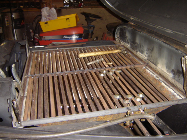Fabricated steel slatted rack or frame mounted in workshop