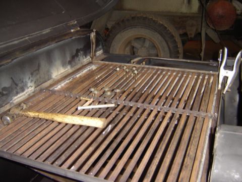 1992 Ford Bronco - Tools and metal grating are visible in the cargo area of a vehicle.