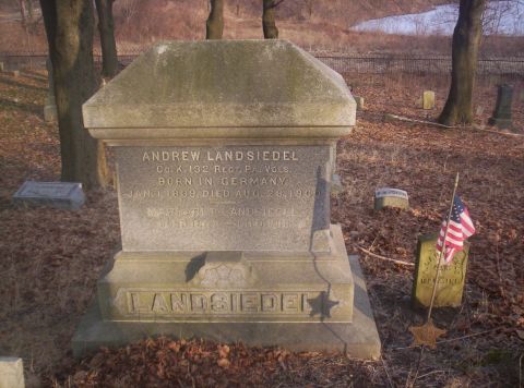 1995 Ford Bronco - A weathered tombstone stands in a cemetery, surrounded by autumn foliage and bare trees.