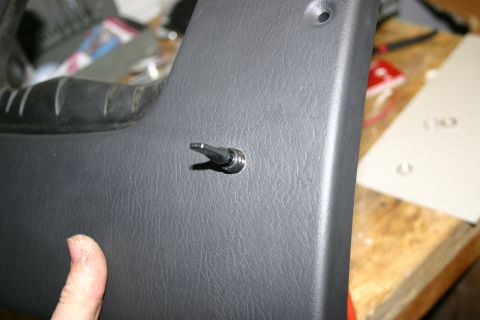 2003 Jeep TJ - A person's thumb is visible near a toggle switch installed on a vehicle's interior panel.