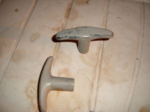 1988 Ford Bronco - Two T-shaped knobs are shown on a light-colored surface, with a watermark for Supermotors.net.