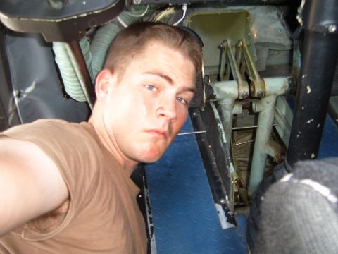 1988 Ford Bronco - A man takes a selfie inside a vehicle, revealing mechanical components and a blue textured floor.