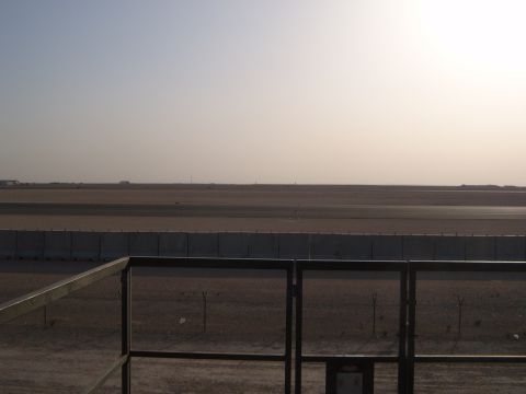 1988 Ford Bronco - View of an airport tarmac under a hazy sky, with a fence and barrier in the foreground.