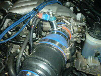 1994 Mazda MX-3 - Close-up view of an engine bay, focusing on the intake system and various hoses and components.