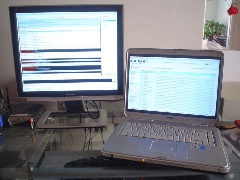 1993 Ford Taurus - A desktop monitor and laptop are set up on a glass table, displaying various text and data.