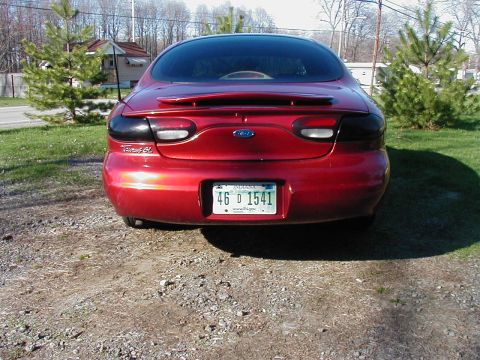 1997 Ford Taurus - Rear view of a red Ford Taurus sedan with tinted taillights and an Indiana license plate.