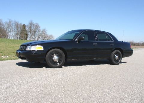 2003 Ford Crown Victoria - A black 2003 Ford Crown Victoria is shown from the side on a clear day.