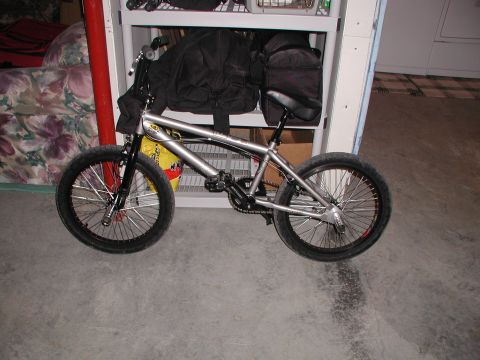 1998 Jeep TJ - A silver BMX bicycle is shown indoors, resting on a concrete floor with storage shelves in the background.