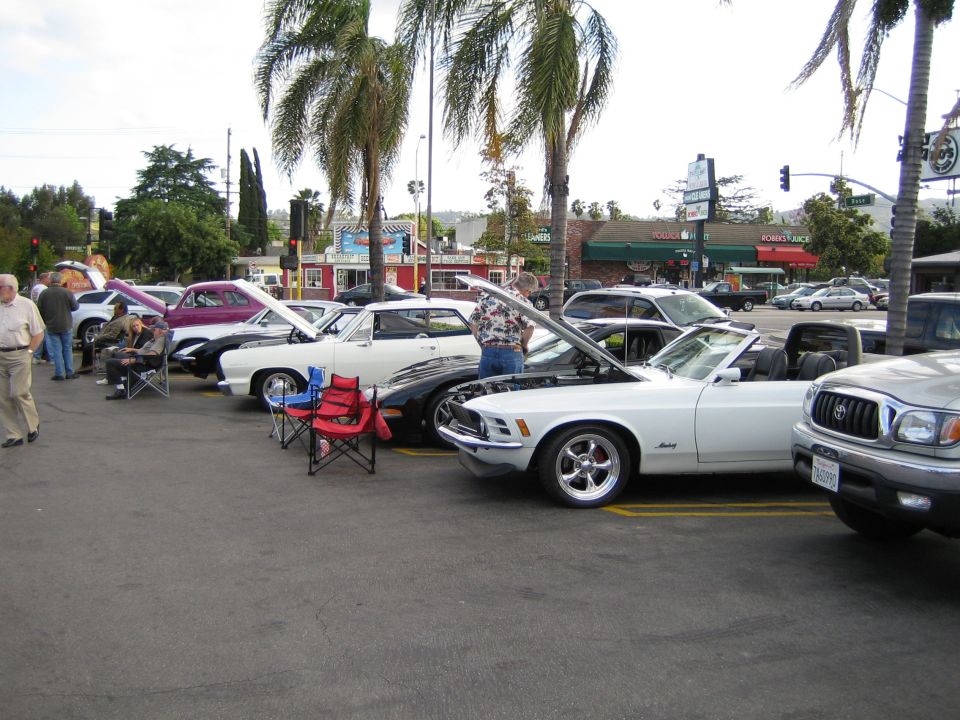White 1970 convertible with hood open, parked at car show