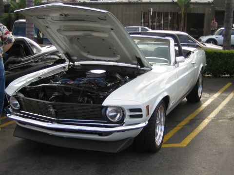 1968 Ford Mustang - White convertible parked in a lot with its hood open, revealing the engine bay.