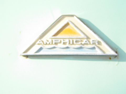 1968 Ford Mustang - Close-up of an Amphicar badge on a light green surface.