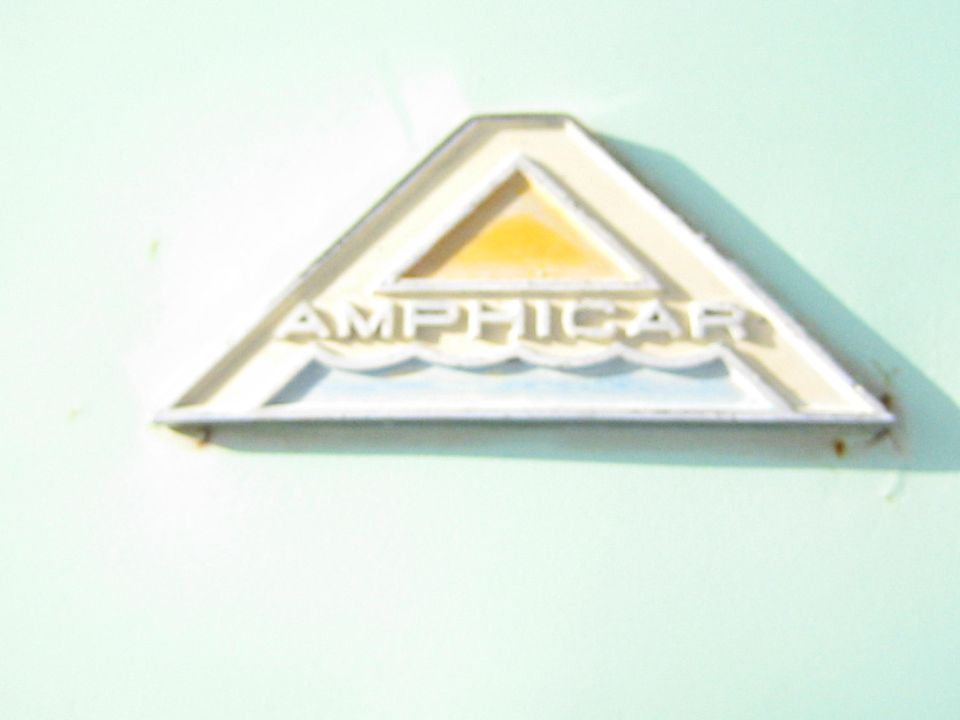 Amphicar badge with yellow sun over blue waves